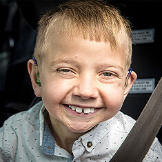 Happy child with hearing disability aid