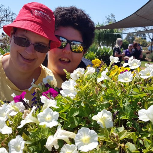 Two ladies looking at flowers in Bundaberg, supported by NDIS services