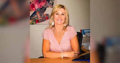 SCSS CEO Cheryl Barrett sitting at desk smiling at camera
