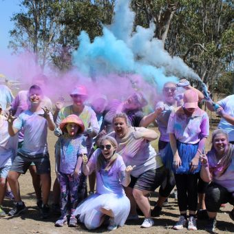 Group of people throwing colours into the air