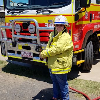 Client dressed in Fire Fighter in front of Fire Truck