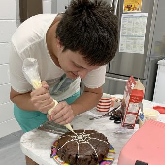Client decorating a cake with Independent Life Skills