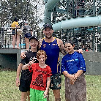 Support worker with kids at waterslide excursion